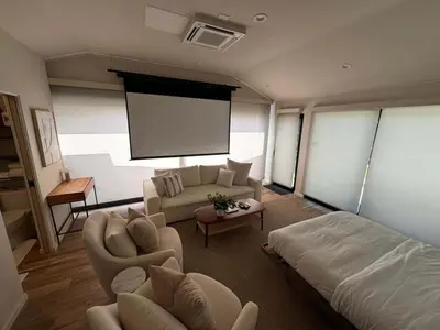 a room with a bed and a couch and a screen at Zenice Beach Luxury Home - Sauna, Cold Plunge, Spa in Los Angeles
