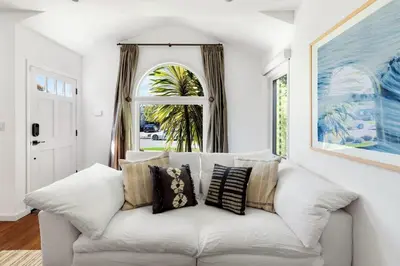a white couch in a living room with a window at Sun-Drenched Spanish Manor Home in Mar Vista in Los Angeles