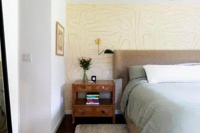 a bedroom with a bed and a nightstand with a vase of flowers at Sun-Drenched Spanish Manor Home in Mar Vista in Los Angeles