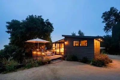 a small cabin with a table and an umbrella at Canyon Crest Cottage and Garden in Topanga Canyon in Topanga
