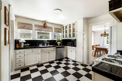 a kitchen with white cabinets and a checkered floor at Charming Walk Street Home - A Venice Beach Hideaway in Los Angeles