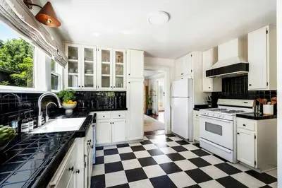 a kitchen with white cabinets and a checkered floor at Charming Walk Street Home - A Venice Beach Hideaway in Los Angeles