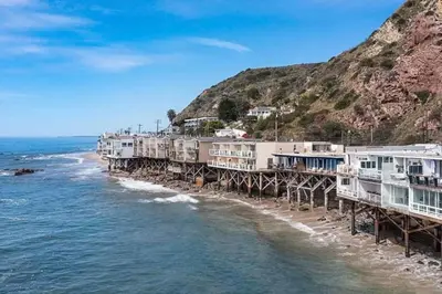 a row of houses on a pier on the beach at Breathe Malibu Ocean Front Condo with Beach Access in Malibu