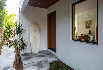 a surfboard leaning against a wall next to a door at San Juan Featured in Architectural Digest Plus Sauna in Los Angeles