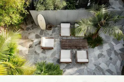 an overhead view of a patio with lounge chairs and palm trees at San Juan Featured in Architectural Digest Plus Sauna in Los Angeles