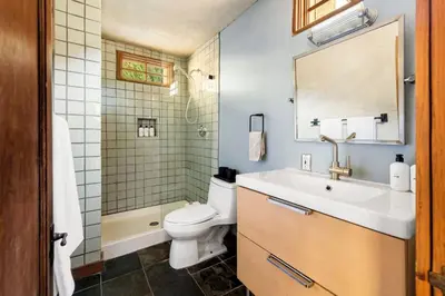 a bathroom with a sink and a toilet and a mirror at Hillside Hideaway Guest House in Topanga Canyon in Topanga