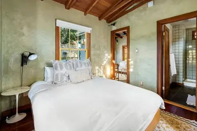 a bedroom with a white bed and a window at Hillside Hideaway Guest House in Topanga Canyon in Topanga