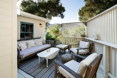 a patio with a couch and chairs on a balcony at Hillside Hideaway Guest House in Topanga Canyon in Topanga
