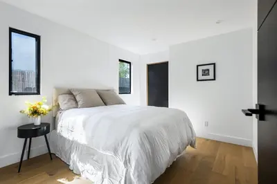 a white bedroom with a large bed and windows at Westminster Bungalow - Front House with Private Entrance in Los Angeles