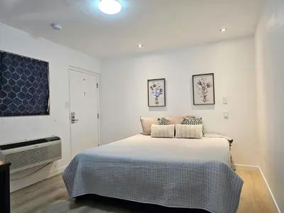 a white bedroom with a bed and a window at Sunrise Inn in Inyokern