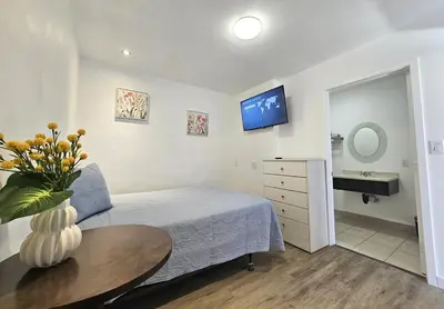 a bedroom with a bed and a table and a sink at Sunrise Inn in Inyokern