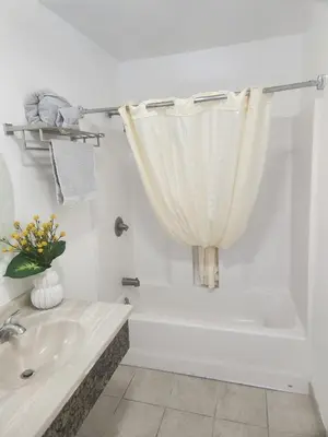 a bathroom with a sink and a bath tub with a shower curtain at Sunrise Inn in Inyokern