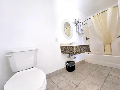 a bathroom with a toilet and a sink and a tub at Sunrise Inn in Inyokern