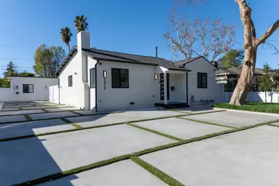 a white house with a tree in front of it at A Brand New Home In Los Angeles in Van Nuys County Court Heliport