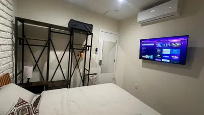 a bedroom with a bed and a flat screen tv on the wall at 2B2B quiet comfy home in Hacienda Heights