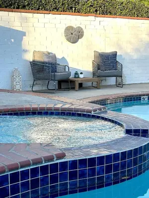 two chairs and a table next to a swimming pool at Tranquil Poolside Oasis with BBQ and Serene Ambiance in North Hollywood