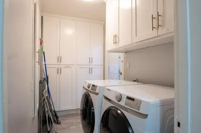 a white laundry room with a washer and dryer at Tranquil Poolside Oasis with BBQ and Serene Ambiance in North Hollywood