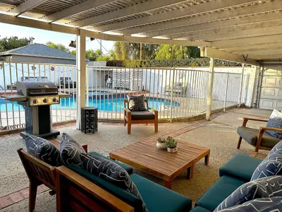 a patio with couches and a table and a grill at Tranquil Poolside Oasis with BBQ and Serene Ambiance in North Hollywood