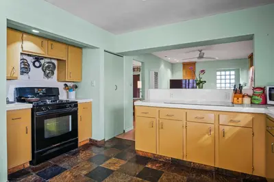 a kitchen with yellow cabinets and a black stove at Steps to Venice Beach Vintage Venice Retreat in Los Angeles