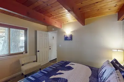 a bedroom with a bed and a wooden ceiling at Whistle Stop Cabin in Lake Arrowhead
