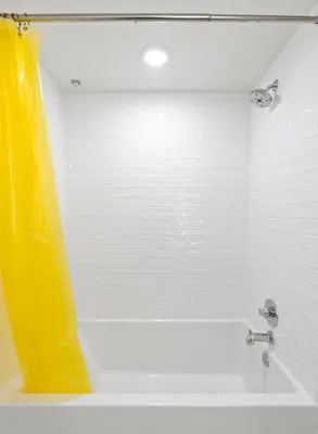 a bathroom with a tub with a yellow shower curtain at Bright Studio on Sunset Blvd, Free Parking, Gym, and Pool in Los Angeles