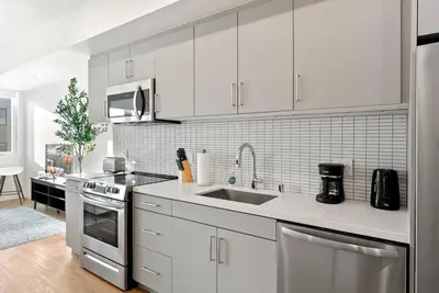 a kitchen with white cabinets and a sink at Bright Studio on Sunset Blvd, Free Parking, Gym, and Pool in Los Angeles