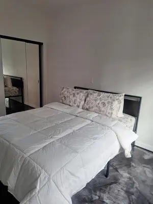 a bedroom with a large bed with white sheets at Beautiful and cosy home in Azusa