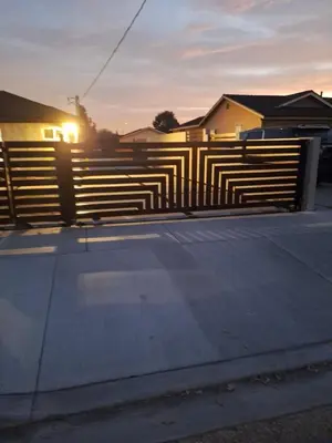 a black and white fence with the sun setting behind it at Beautiful and cosy home in Azusa