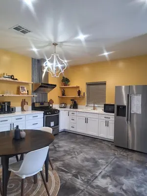 a kitchen with white cabinets and a stainless steel refrigerator at Beautiful and cosy home in Azusa