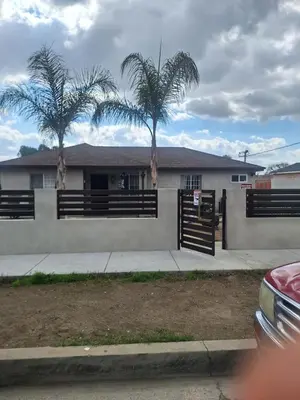 a house with two palm trees in front of it at Beautiful and cosy home in Azusa