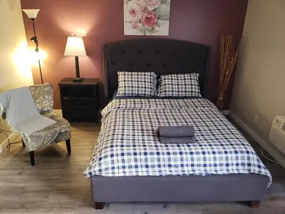 a bedroom with a bed and a chair and lamp at Beverly Hills Suite with Balcony in Los Angeles