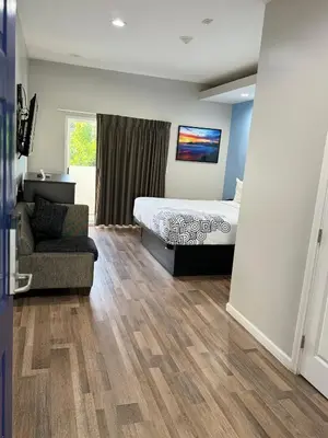 a bedroom with a bed and a chair and a couch at Moonlite Inn in Redondo Beach