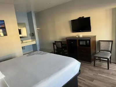 a hotel room with a bed and a flat screen tv at Moonlite Inn in Redondo Beach