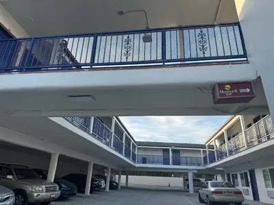 a balcony in a building with cars parked in a parking lot at Moonlite Inn in Redondo Beach