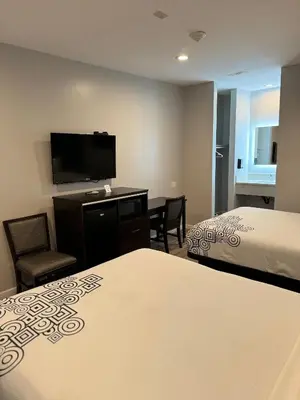 a hotel room with two beds and a flat screen tv at Moonlite Inn in Redondo Beach