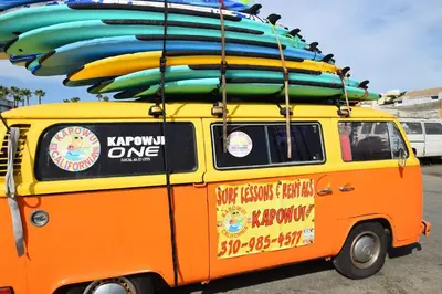 an orange van with surfboards on top of it at Maison on the Beach in Los Angeles