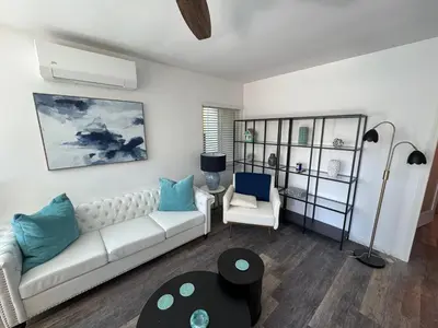a living room with a white couch and blue pillows at Maison on the Beach in Los Angeles