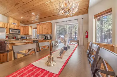 a kitchen with a long table and a dining room at TimberWood Cabin- 3 Bdr - 2 Bth - Big Game room - Prime Location in Big Bear Lake in Big Bear Lake
