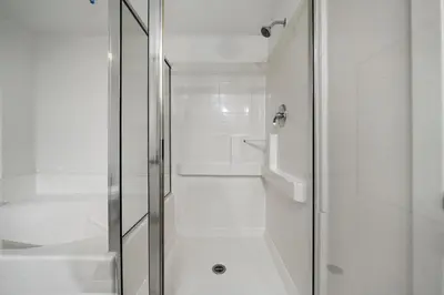 a white bathroom with a shower and a toilet at Location Walk to the beach Chic Condo! in Los Angeles