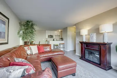 a living room with a leather couch and a fireplace at 2 Mi to Beaches Condo with Patio in Port Hueneme! in Port Hueneme