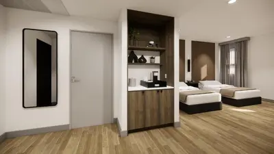 a living room with two couches and a mirror at Kins Hotel in Los Angeles