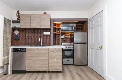a kitchen with stainless steel appliances and wooden cabinets at Walk to Melrose Ave - World Famous Shops and Restaurants in Los Angeles