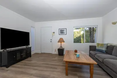 a living room with a couch and a flat screen tv at Walk to Melrose Ave - World Famous Shops and Restaurants in Los Angeles