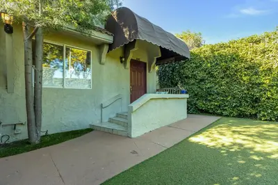 a small house with a porch with a staircase at Walk to Melrose Ave - World Famous Shops and Restaurants in Los Angeles