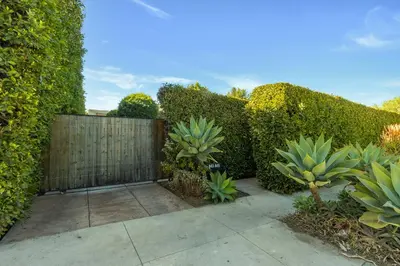 a garden with a fence and some plants at Walk to Melrose Ave - World Famous Shops and Restaurants in Los Angeles