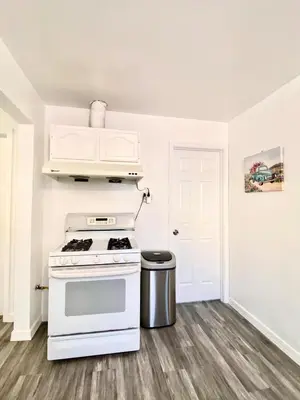 a kitchen with a stove and a trash can at 1BR Pink Cozy House near DTLA in Rosemead