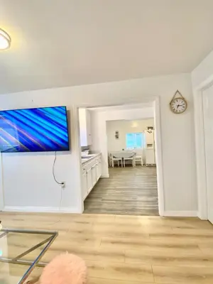 a living room with a flat screen tv on a wall at 1BR Pink Cozy House near DTLA in Rosemead