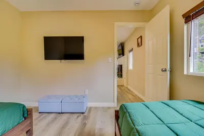 a bedroom with two beds and a flat screen tv at 4 Mi to Lake Arrowhead Cabin with Grill and Deck! in Twin Peaks