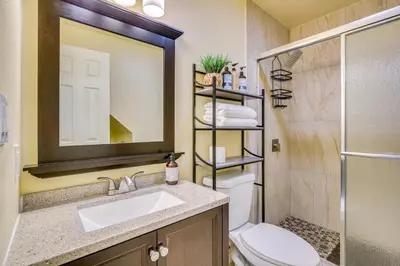 a bathroom with a sink and a toilet and a mirror at 4 Mi to Lake Arrowhead Cabin with Grill and Deck! in Twin Peaks
