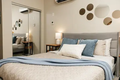 a bedroom with a large bed with blue and white pillows at Signature One Bedroom Apartment in Los Angeles